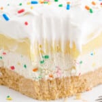 Vertical pin image featuring stacked birthday cake delight bars on a plate with whipped topping and vibrant sprinkles.