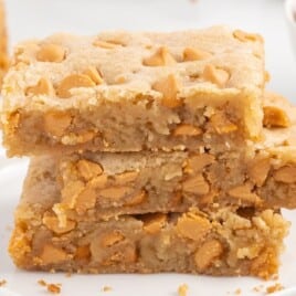Close-up of soft, chewy butterscotch bars stacked on top of each other with a golden, slightly crispy top layer.