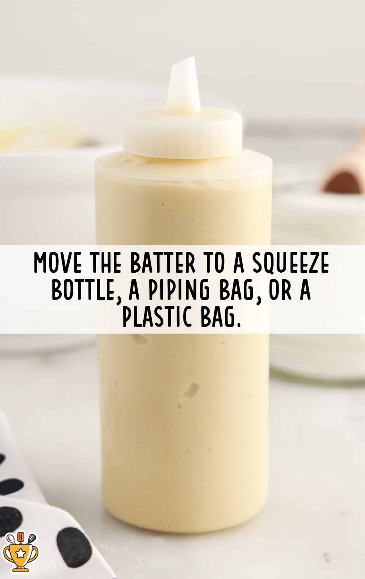 Plastic squeeze bottle filled with smooth funnel cake batter ready for piping into hot oil.