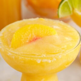 a half photo of peach margarita in a glass