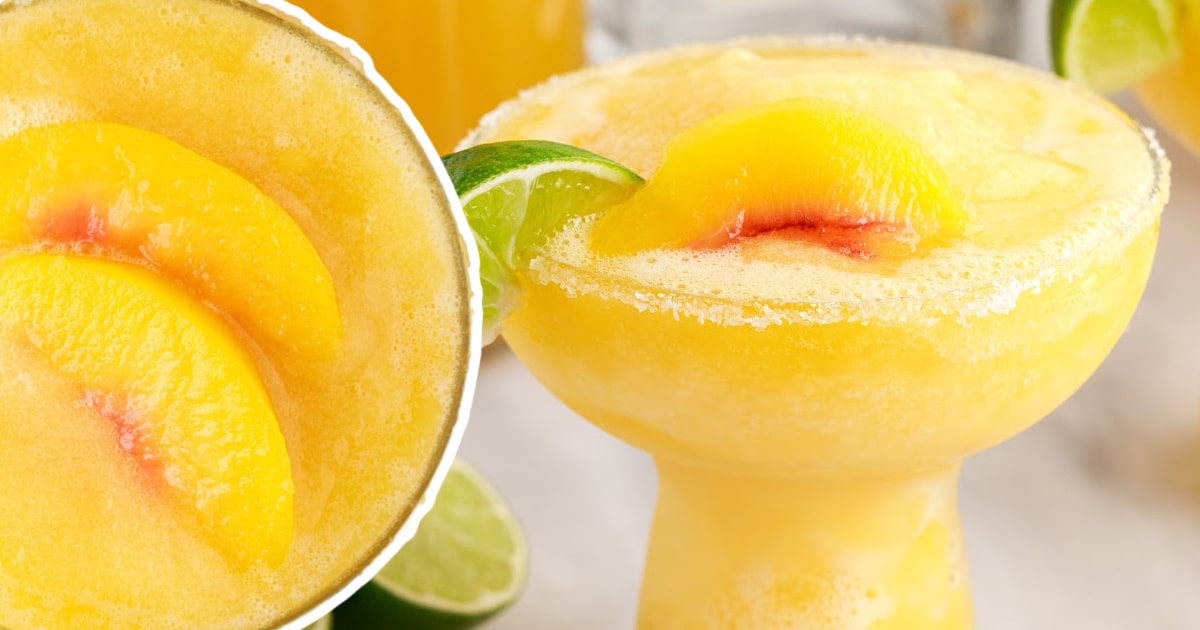 Bright and refreshing peach margarita garnished with a lime slice and served over ice in a cocktail glass