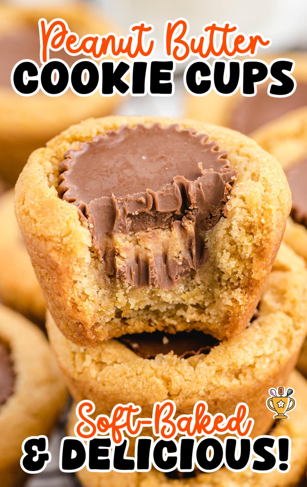 Peanut butter cookie cups on a white tray with a bite taken out of one, showing the gooey chocolate center inside.