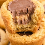 Overhead view of peanut butter cookie cups in a muffin tin, topped with mini peanut butter cups and styled for Pinterest.
