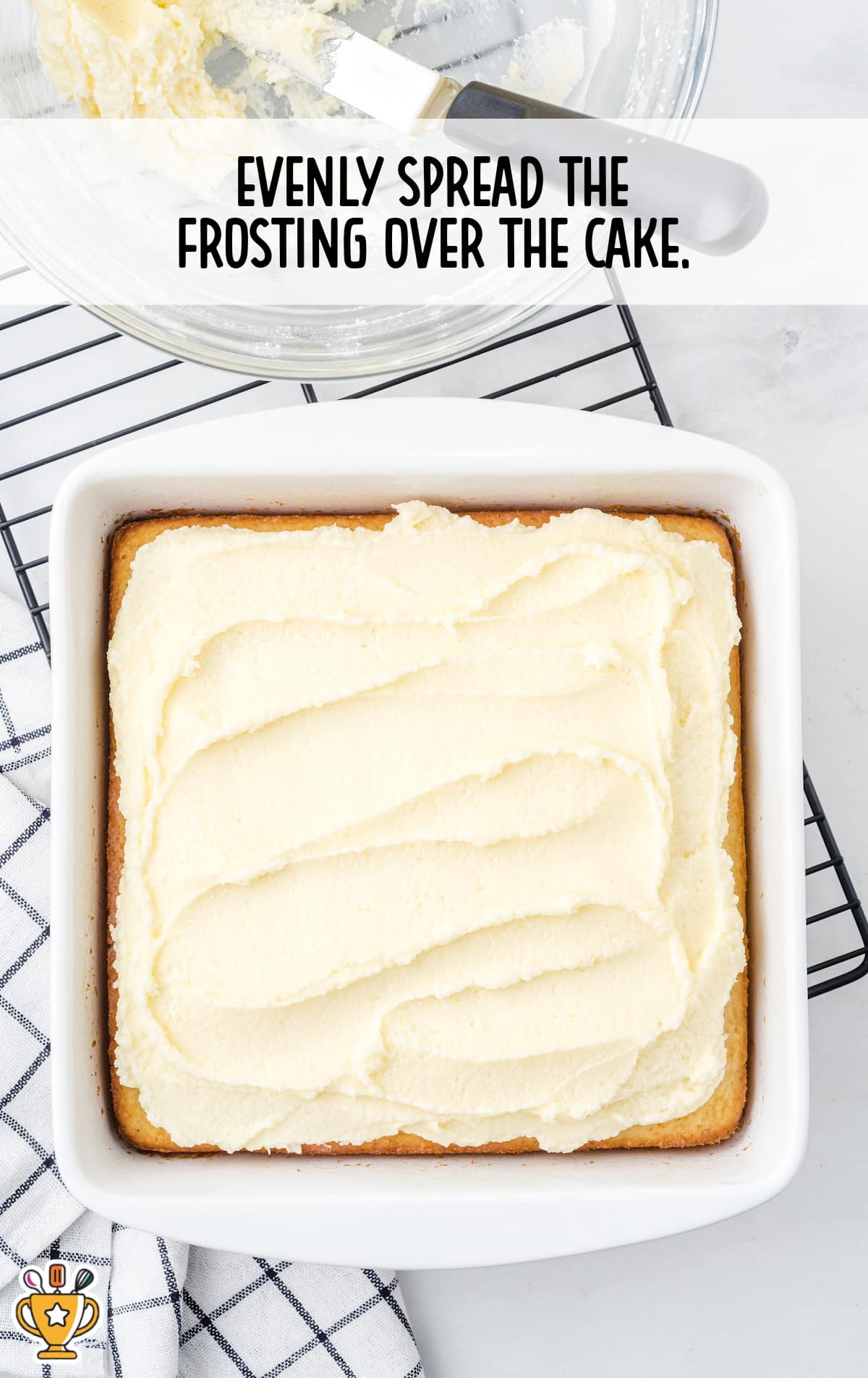 Freshly frosted vanilla snack cake resting in a baking dish, ready to be sliced and served