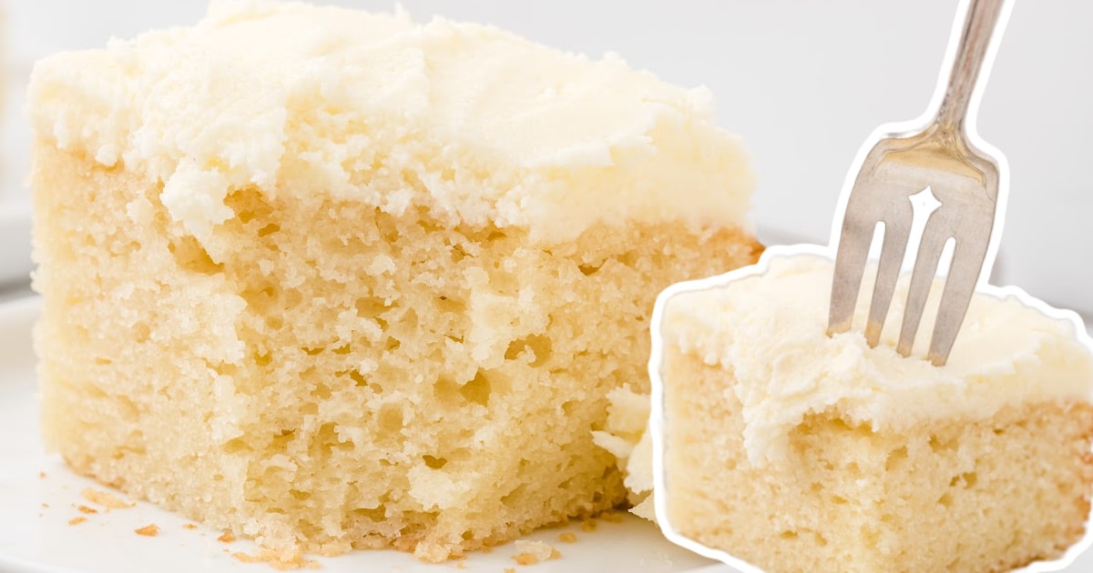 A cleanly sliced piece of vanilla snack cake on a plate with a silver fork next to it.
