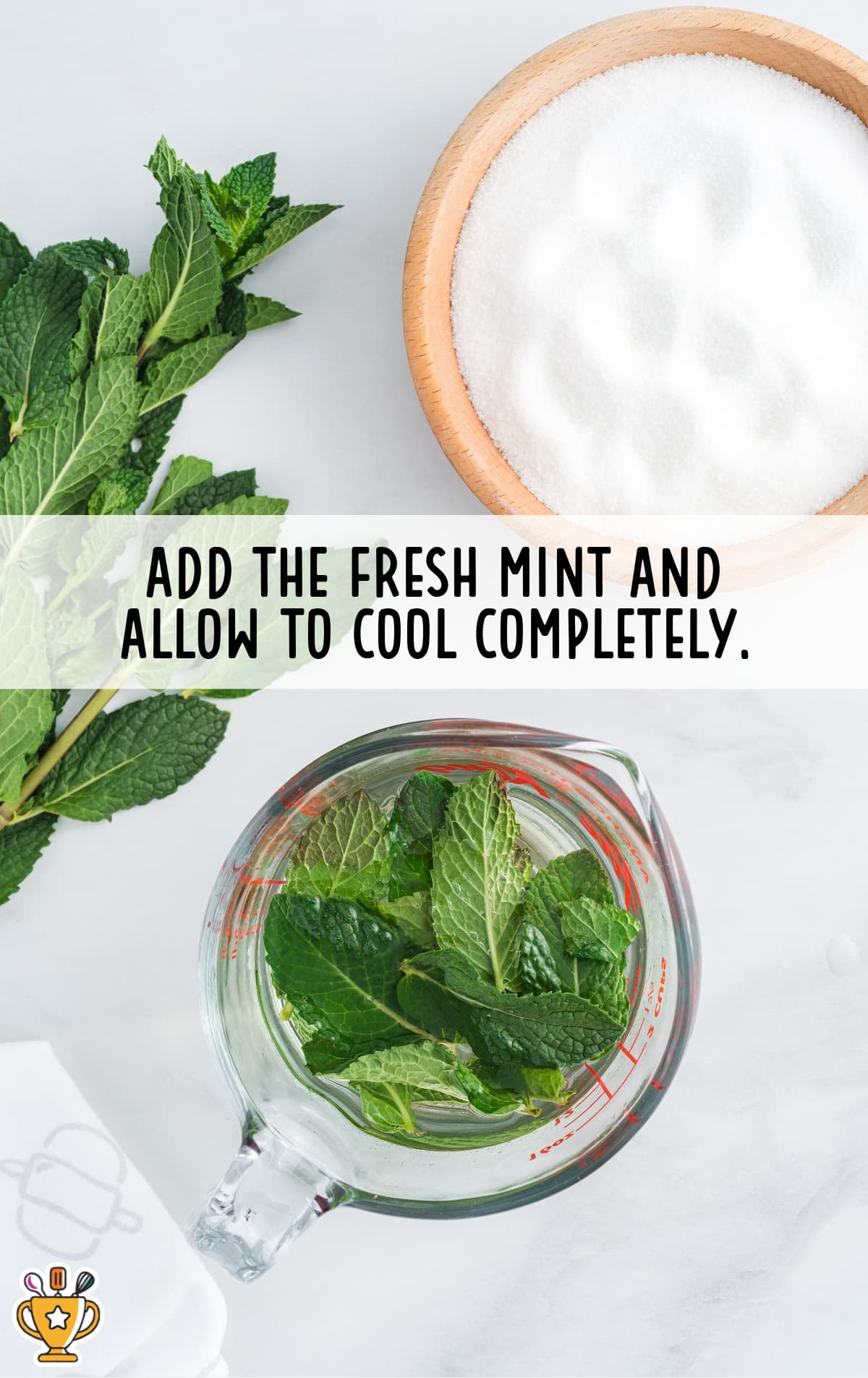 Overhead view of fresh mint leaves and granulated sugar in a bowl, next to a measuring cup filled with mint steeping in liquid.