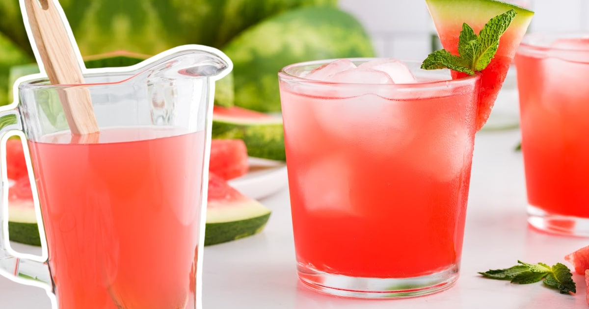 Top view of an iced watermelon cocktail garnished with mint and a small watermelon wedge, surrounded by additional cocktail glasses.
