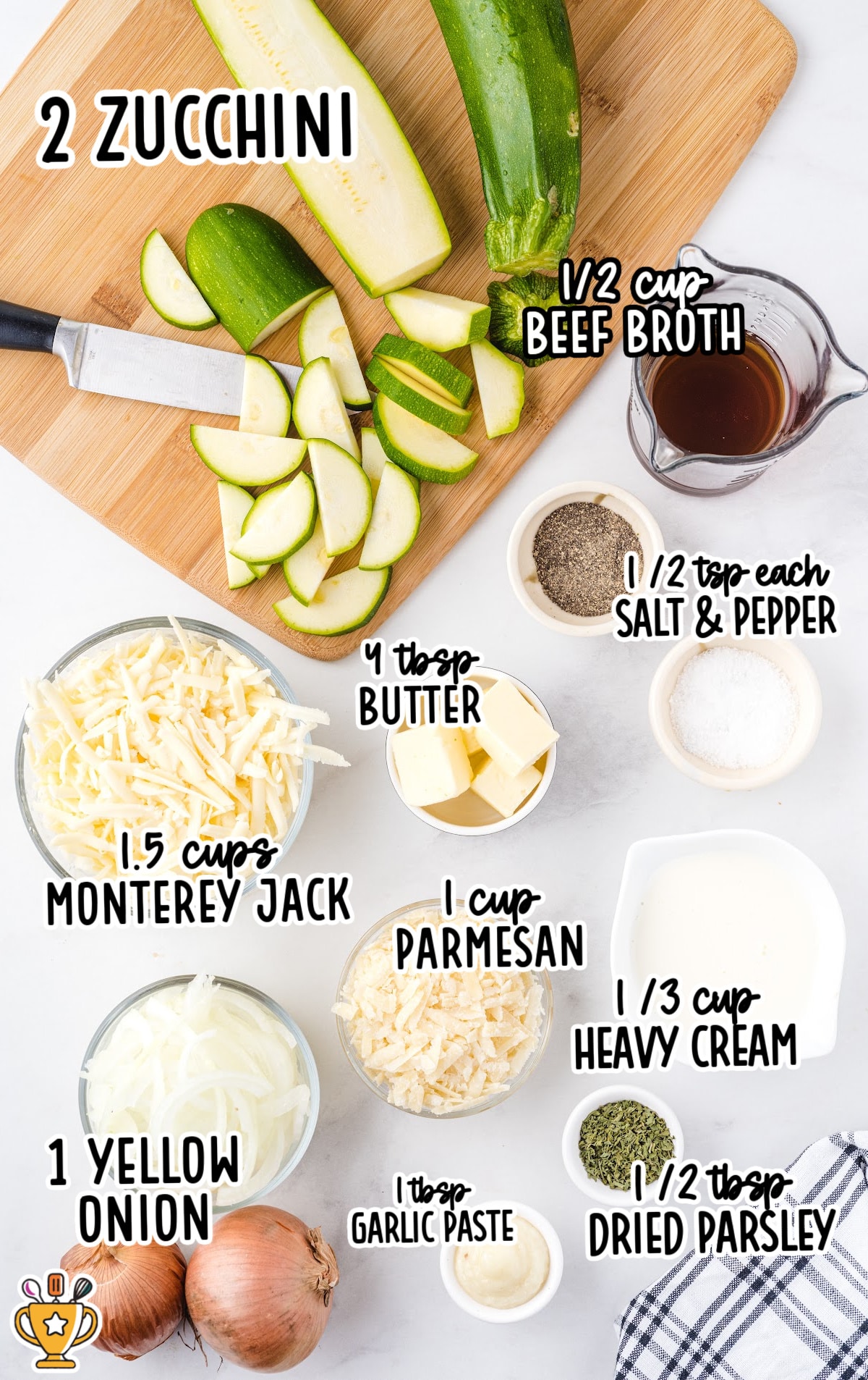 Overhead view of fresh and prepared zucchini gratin ingredients including sliced zucchini, shredded cheese, butter, garlic paste, and seasonings.