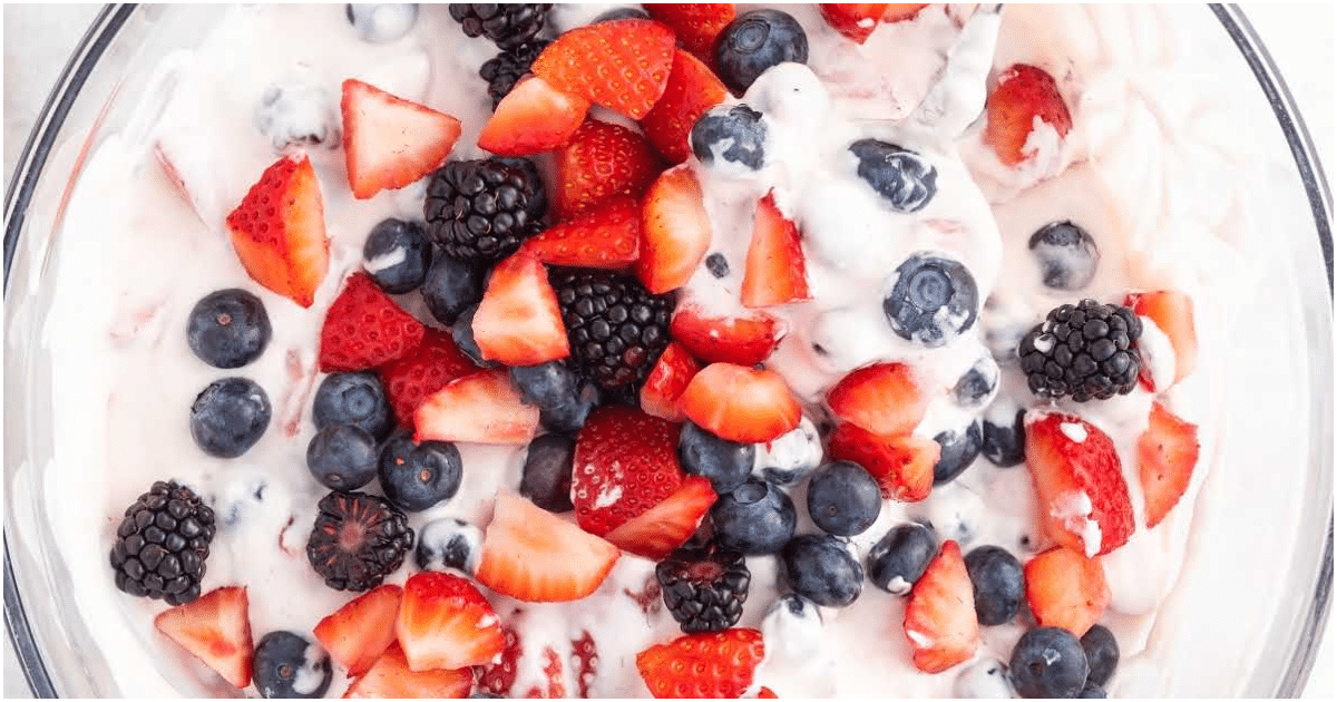 Mixed berry cheesecake salad with blueberries, raspberries, and strawberries folded into a fluffy cream cheese base
