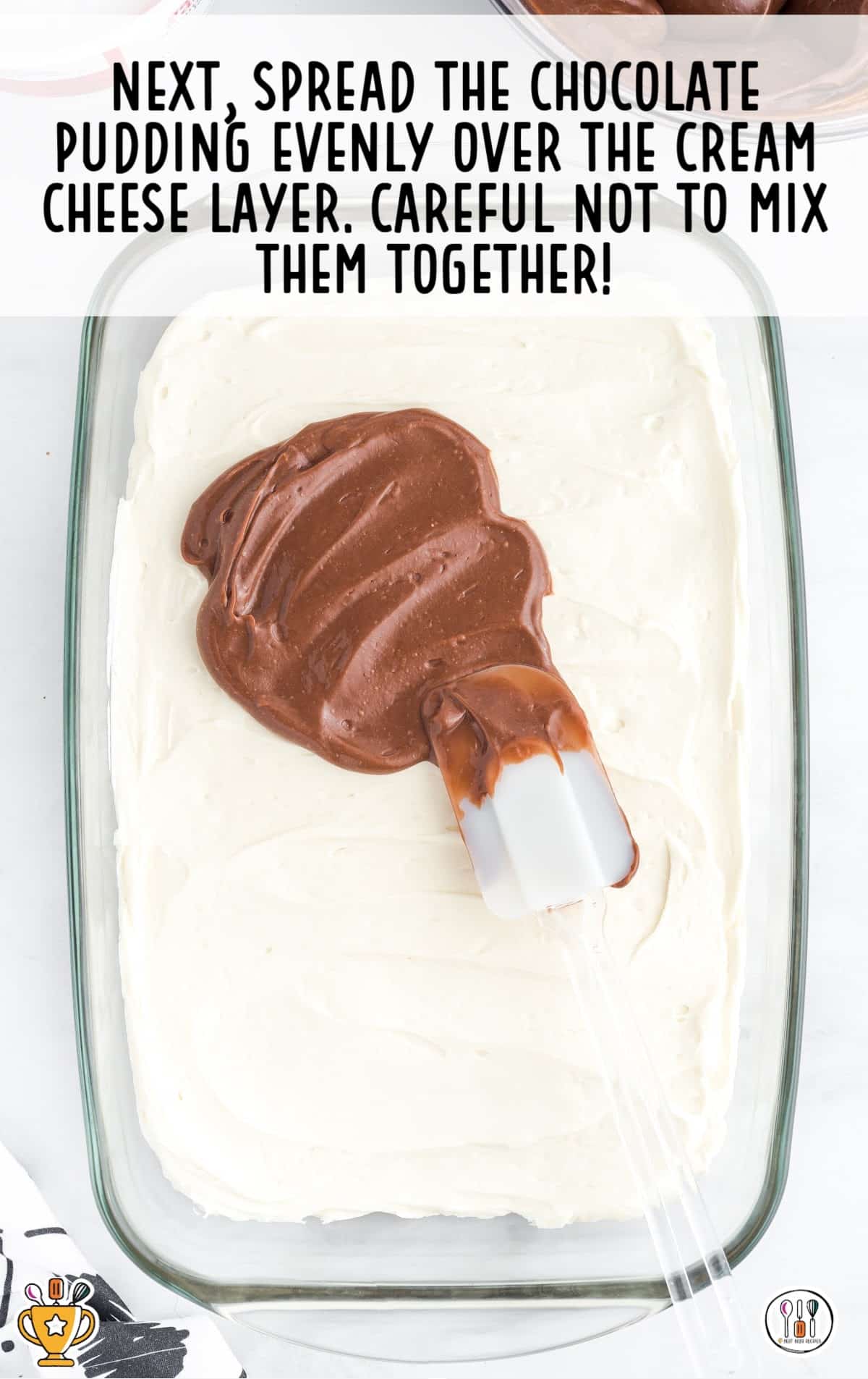 Image showing chocolate pudding being carefully spread over a cream cheese layer without mixing the two together.