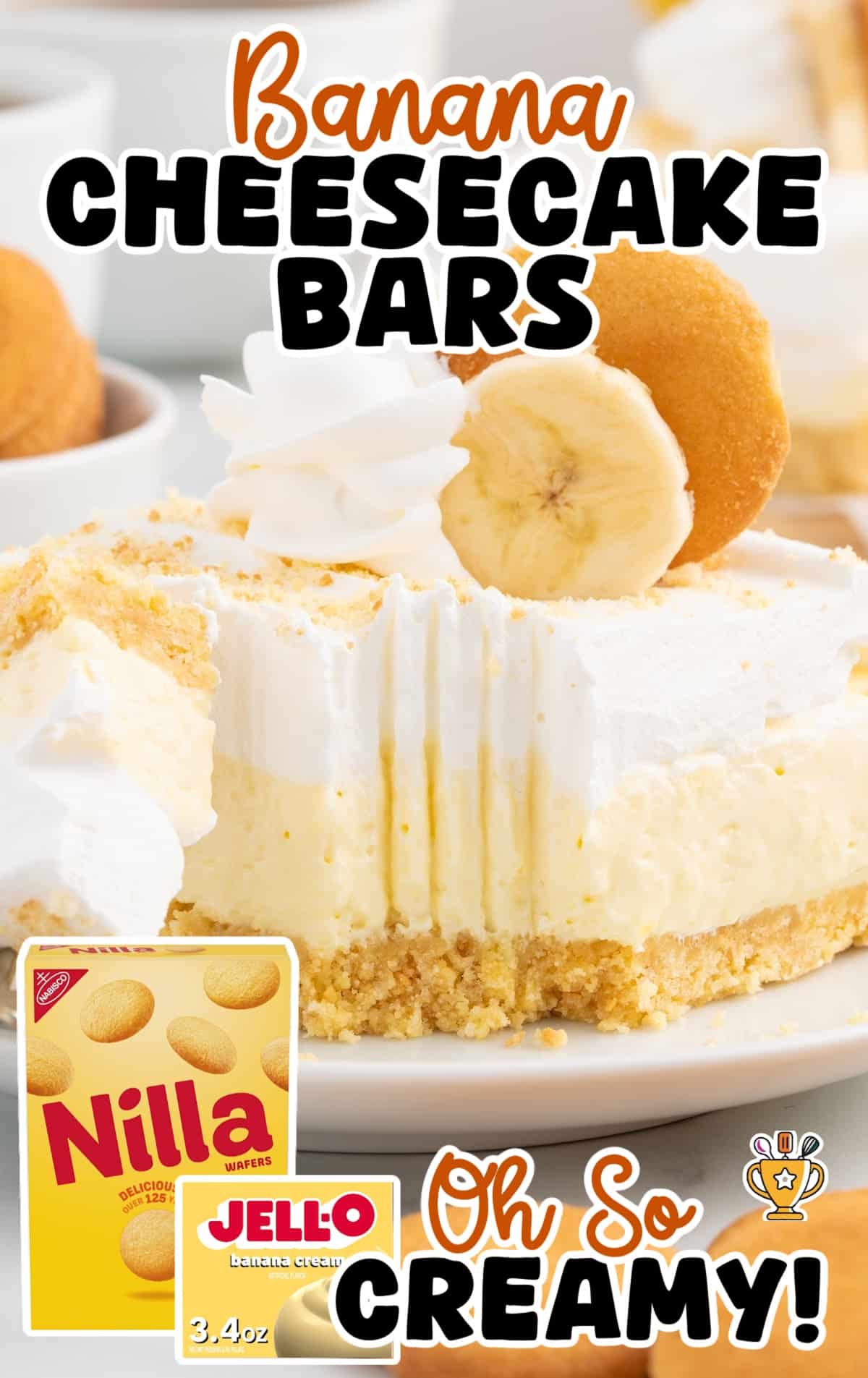 Slice of banana cheesecake bar with whipped topping, banana slice, and Nilla wafer on a white plate, cookies in the background.