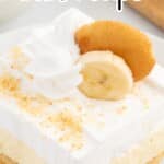Close-up of a banana pudding cheesecake bar with a graham cracker crust, whipped cream, banana slice, and Nilla wafer, labeled recipe pin.