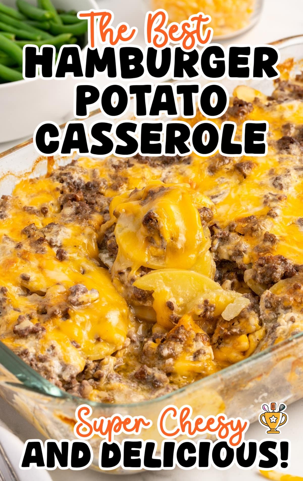 The best hamburger potato casserole with layers of potatoes, ground beef, and melted cheese, served with green beans on the side.