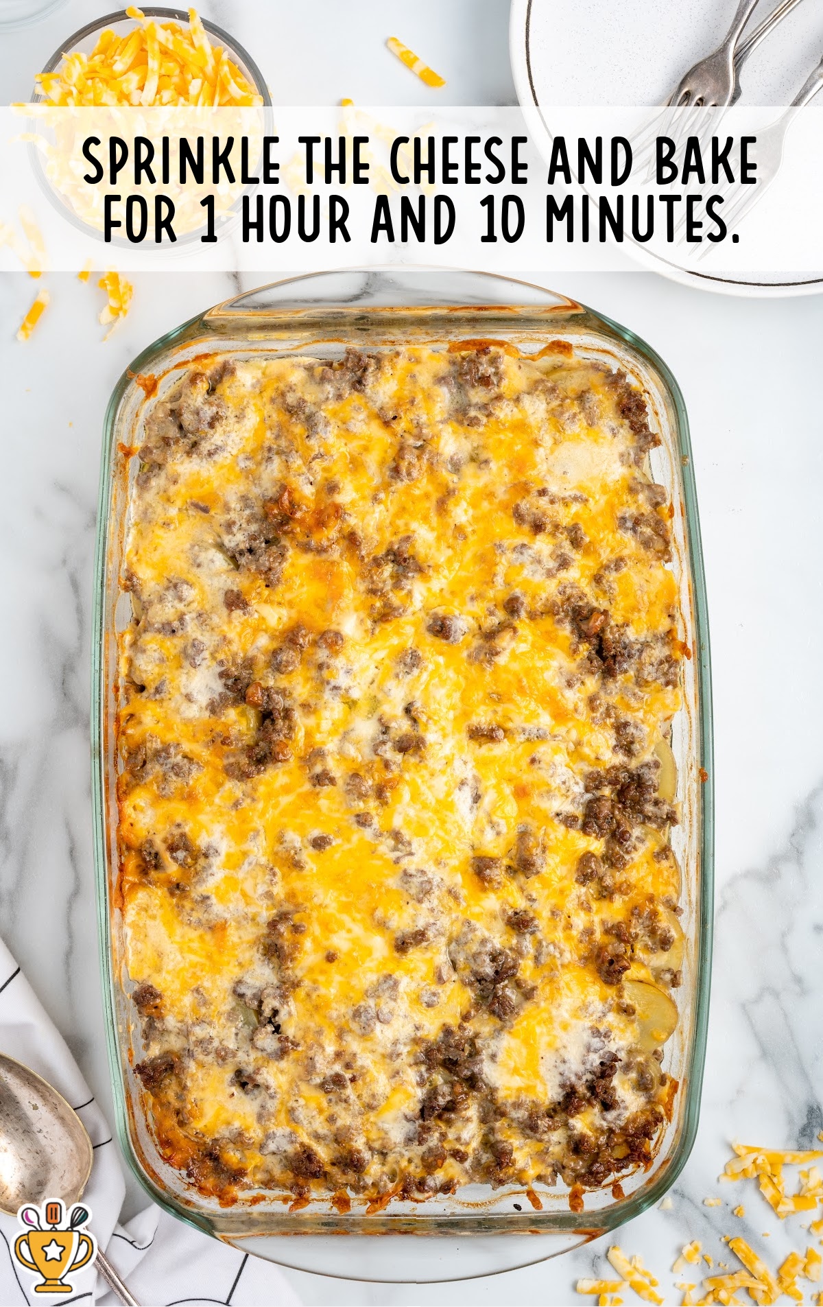 Finished hamburger potato casserole baked in a glass dish, topped with golden melted cheese and browned ground beef.