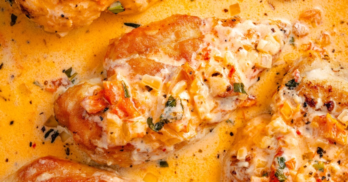 Golden Marry Me Chicken in a creamy sauce with onions and tomatoes, plated with spaghetti for a comforting dinner.