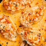 Golden chicken breasts simmering in creamy sauce inside a skillet with text overlay saying "Marry Me Chicken Perfect With Pasta."