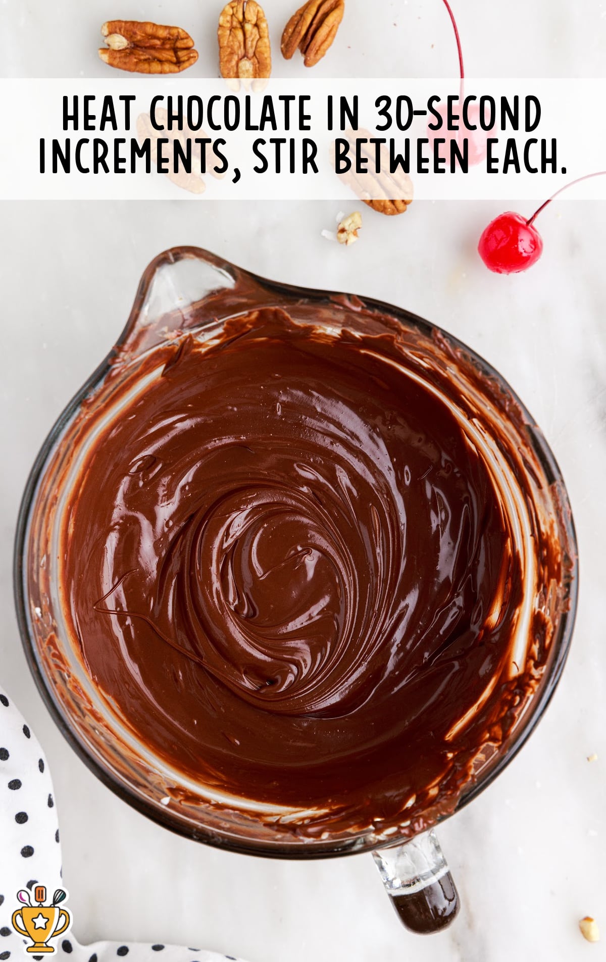 Melted chocolate in a glass bowl after heating and stirring, with a smooth and glossy texture perfect for dipping candy.