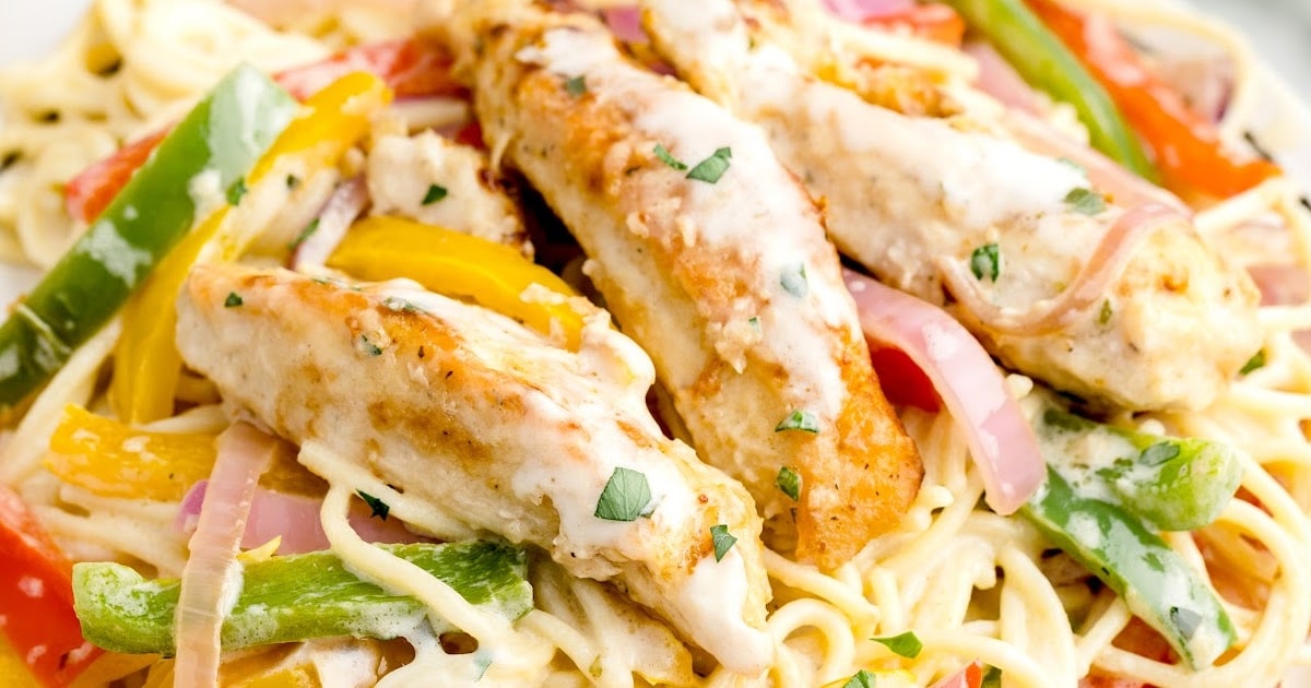 Two plates of creamy chicken scampi pasta featuring grilled chicken, green and red peppers, yellow bell peppers, and onions.