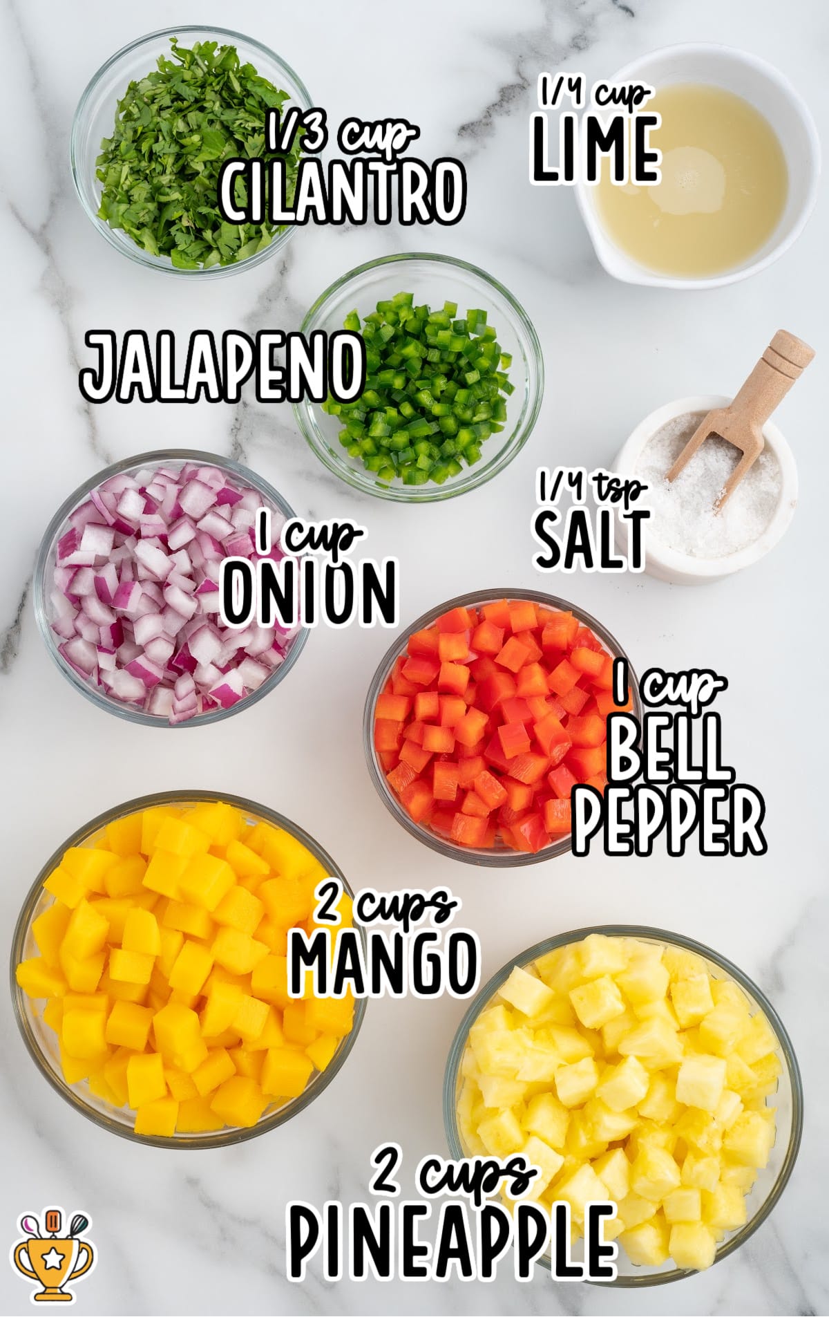 Top-down view of salsa ingredients in bowls on a marble surface, including chopped mango, pineapple, onion, bell pepper, jalapeño, cilantro, lime juice, and salt.