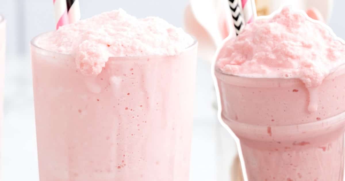 Two tall glasses of frothy strawberry frosty with striped straws, close-up view showing fluffy pink texture spilling slightly over the rim.