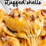 Cheesy taco stuffed pasta shell being lifted from a casserole dish with gooey melted cheese stretching from the shell to the pan.