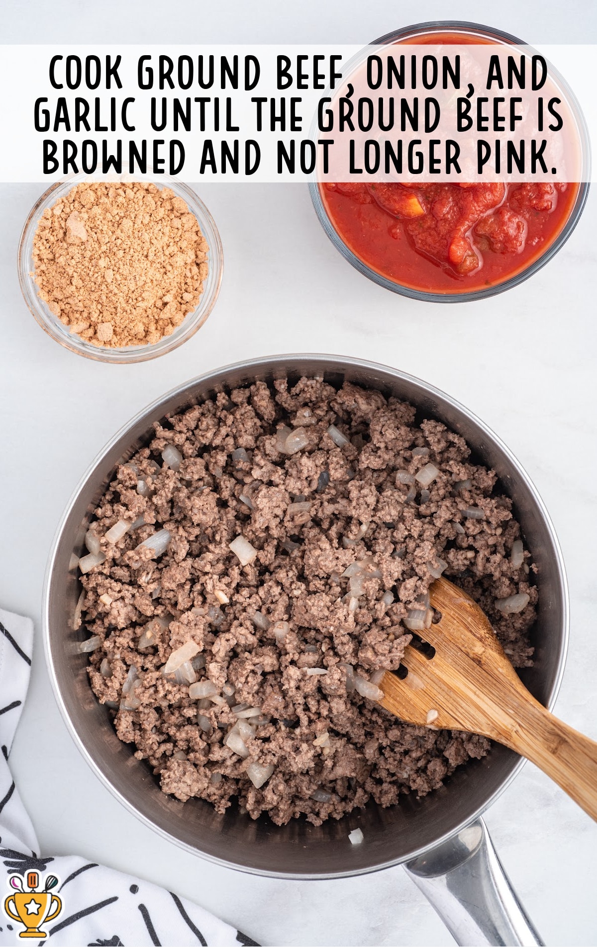 Ground beef cooked with chopped onions in a skillet with a wooden spoon, shown alongside bowls of taco seasoning and salsa.