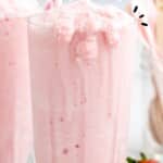 Tall glass of pink strawberry frosty with bold text &ldquo;Easy Wendy&rsquo;s Strawberry Frosty Recipe,&rdquo; labeled &ldquo;So Smooth & Creamy!&rdquo; with fresh strawberries on the side.