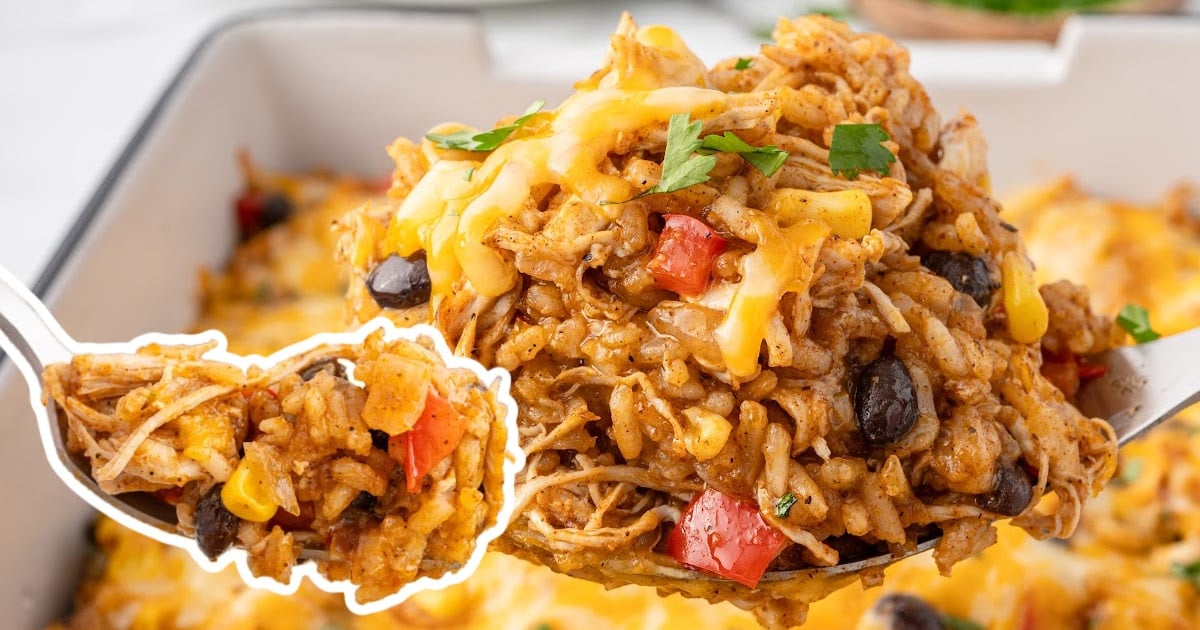 Plate of Mexican chicken and rice casserole topped with sour cream and cilantro next to casserole dish, easy cheesy chicken dinner.