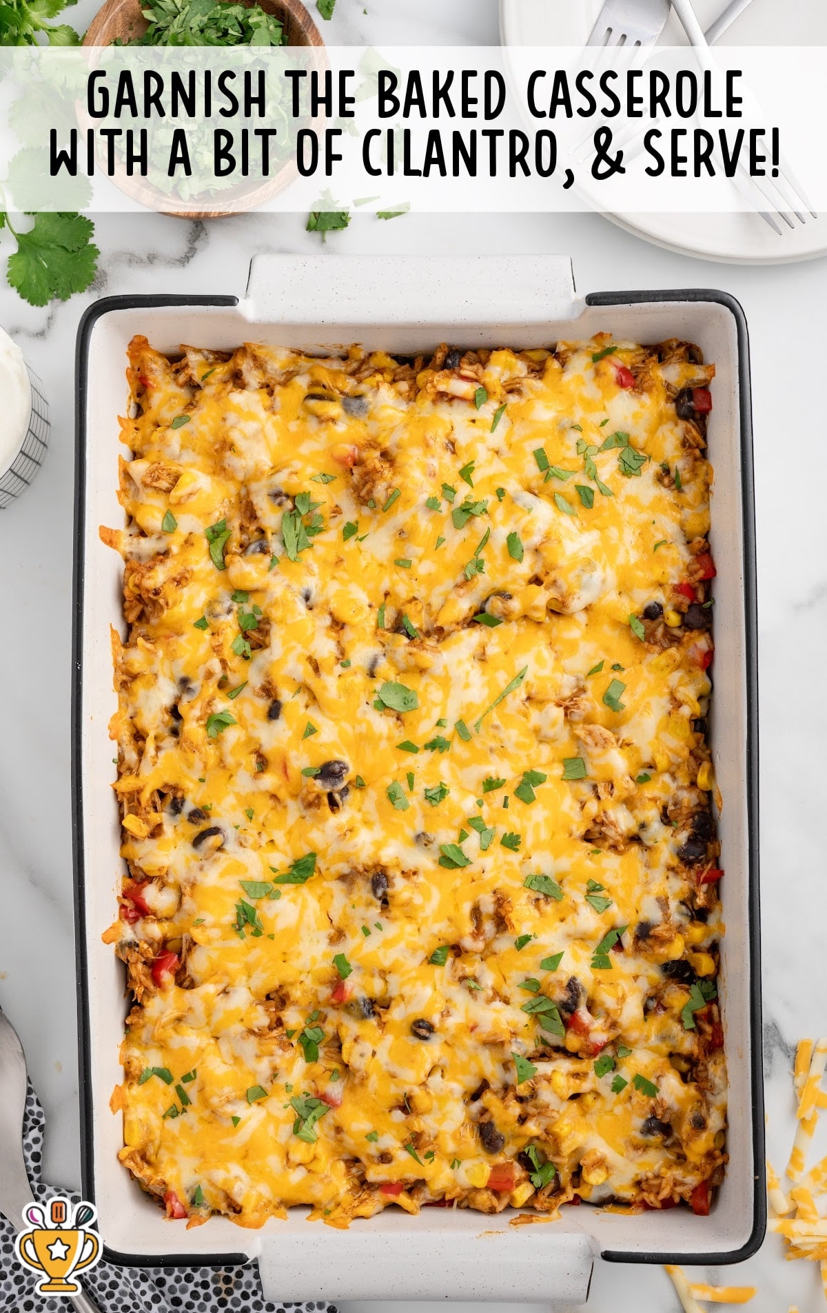 Baked Mexican chicken and rice casserole topped with melted cheddar jack cheese and garnished with fresh cilantro, ready to serve.