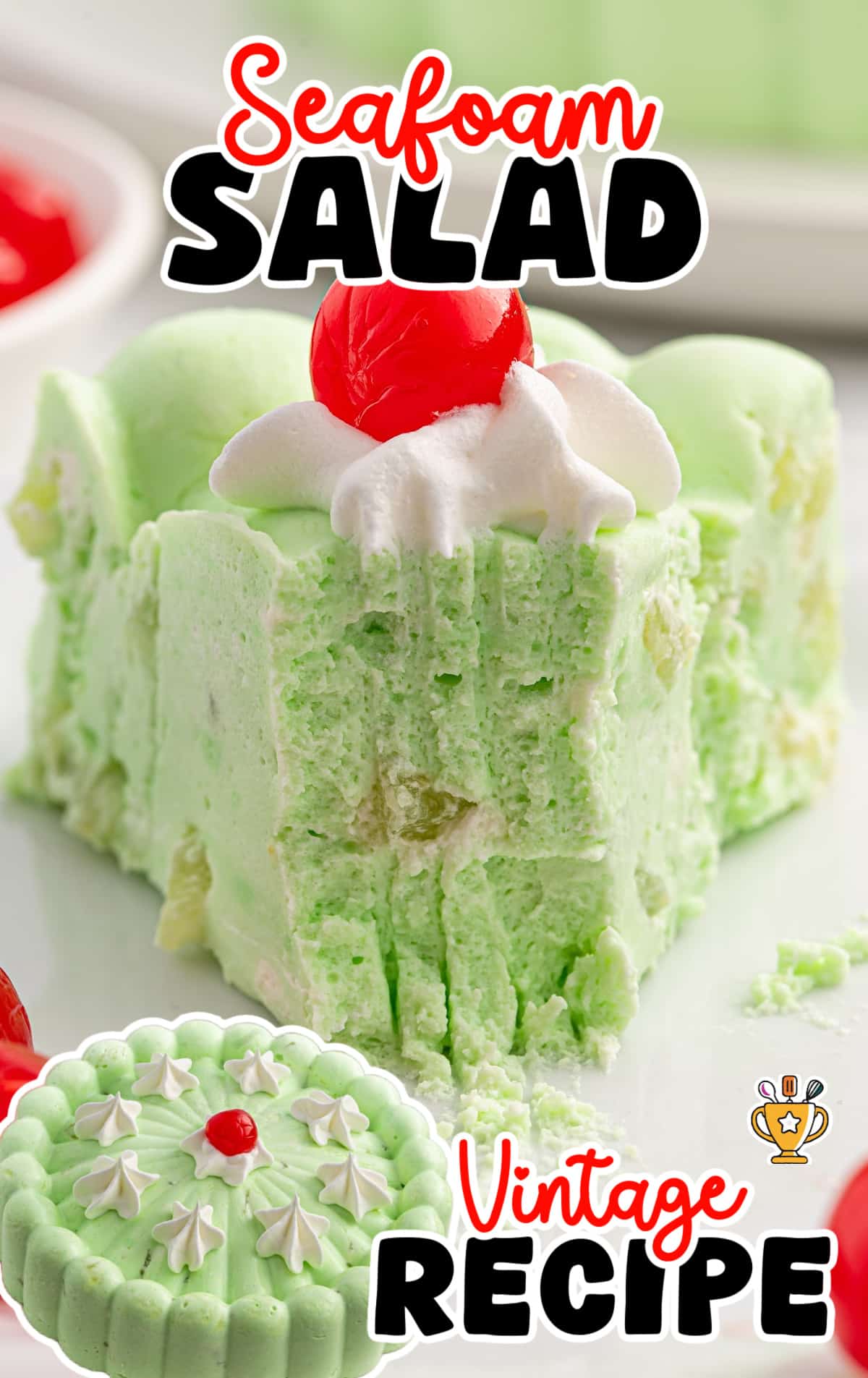A close-up of a square slice of seafoam salad topped with whipped cream and a maraschino cherry, showcasing its fluffy texture and pastel green color.