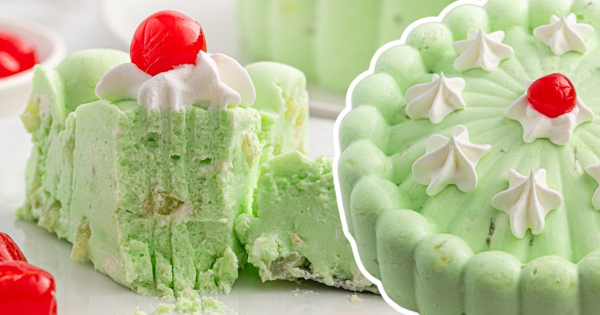 A soft, square slice of seafoam salad topped with whipped cream and a maraschino cherry, served with extra cherries on the side.