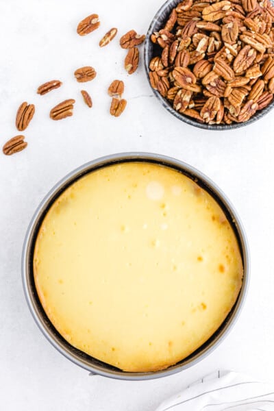 Turn off the oven and leave the cheesecake inside with the oven door closed for 30 minutes. Then crack the door open for another 30 minutes while the oven and cheesecake cool.