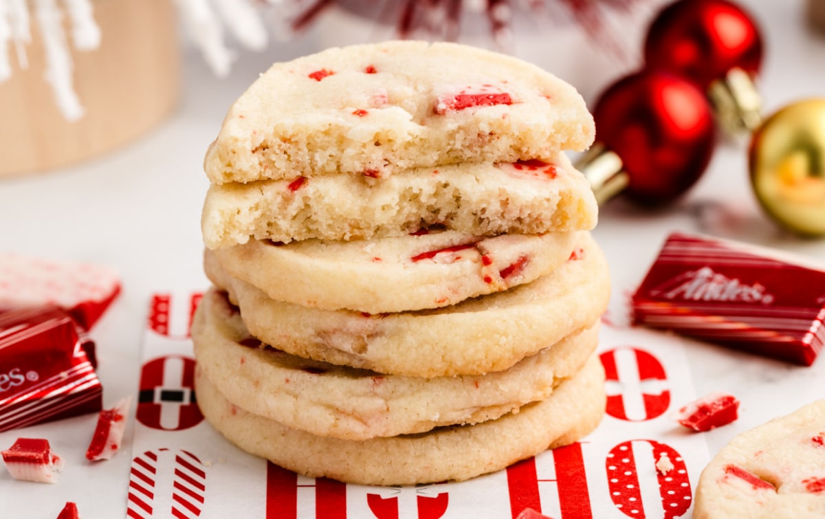 Stack of festive candy cane shortbread cookies with red peppermint candy pieces