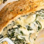 Close-up of golden spinach stuffed chicken breast filled with creamy spinach and melty cheese, styled as an easy but fancy dinner recipe.