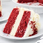 Slice of red velvet cheesecake cake showing distinct cake and cheesecake layers with cream cheese frosting