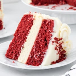 Slice of red velvet cheesecake cake showing distinct cake and cheesecake layers with cream cheese frosting