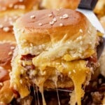 Baked bacon cheeseburger sliders with soft Hawaiian rolls, melted cheddar cheese, seasoned ground beef, and crispy bacon, shown ready to serve.