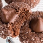 Chocolate kiss cookies coated in coarse sugar, one broken open to show the chocolate interior, with text reading “Soft & Chewy Chocolate Kiss Cookies” and “Topped with Hershey’s Kiss.”