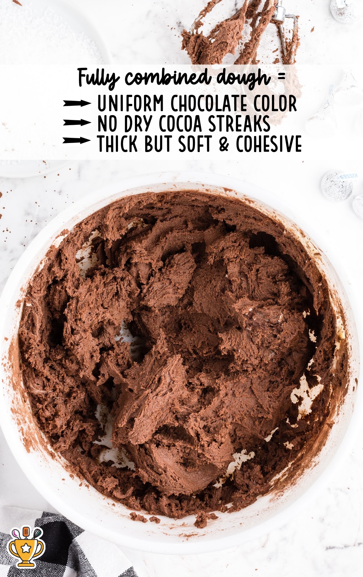 Chocolate cookie dough fully mixed in a bowl, showing a uniform chocolate color, with text overlay listing “Fully combined dough: uniform chocolate color, no dry cocoa streaks, thick but soft and cohesive.”