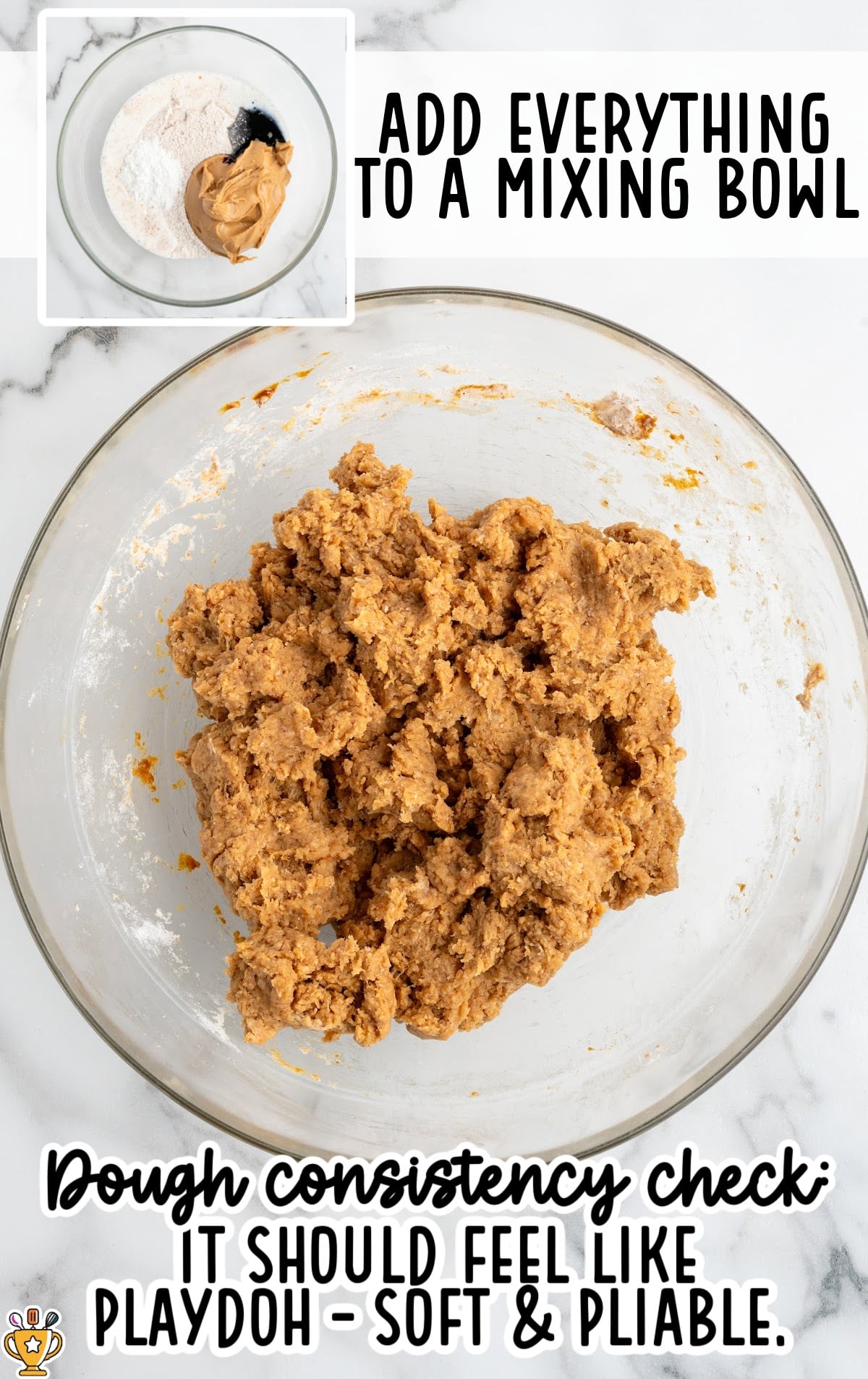 An overhead step-by-step process image showing a clear glass mixing bowl filled with fully combined dog treat dough. The dough is light brown, thick, and slightly textured, resembling soft Play-Doh. Above the bowl, bold text reads “ADD EVERYTHING TO A MIXING BOWL.” At the bottom, large caption text says “Dough consistency check: IT SHOULD FEEL LIKE PLAYDOH – SOFT & PLIABLE.” In the top-left corner, a small inset image shows the unmixed ingredients in the bowl, including whole wheat flour, peanut butter, and dark molasses, on a white marble background.