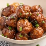 Recipe card image for Asian turkey meatballs showing glazed meatballs on toothpicks with an ingredient list, including ground turkey, panko, soy sauce, hoisin, honey, ginger, garlic, and sesame oil.