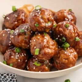 Recipe card image for Asian turkey meatballs showing glazed meatballs on toothpicks with an ingredient list, including ground turkey, panko, soy sauce, hoisin, honey, ginger, garlic, and sesame oil.