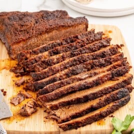 Recipe card image showing sliced slow-cooked brisket on a cutting board with two foil pans of cooked brisket below. Text on the image reads &ldquo;Slow Cooking Brisket in Oven&rdquo; followed by ingredient text: &ldquo;4&ndash;5 lb beef brisket, 2 tbsp brown sugar, 1 ½ tbsp smoked paprika, 1 tbsp chili powder, 1 tbsp garlic powder, 1 tbsp onion powder, ½ tsp dry mustard powder, ½ tsp cumin, 1 tbsp kosher salt, ½ tsp black pepper,&rdquo; and &ldquo;Find more recipes at thebestblogrecipes.com.&rdquo;