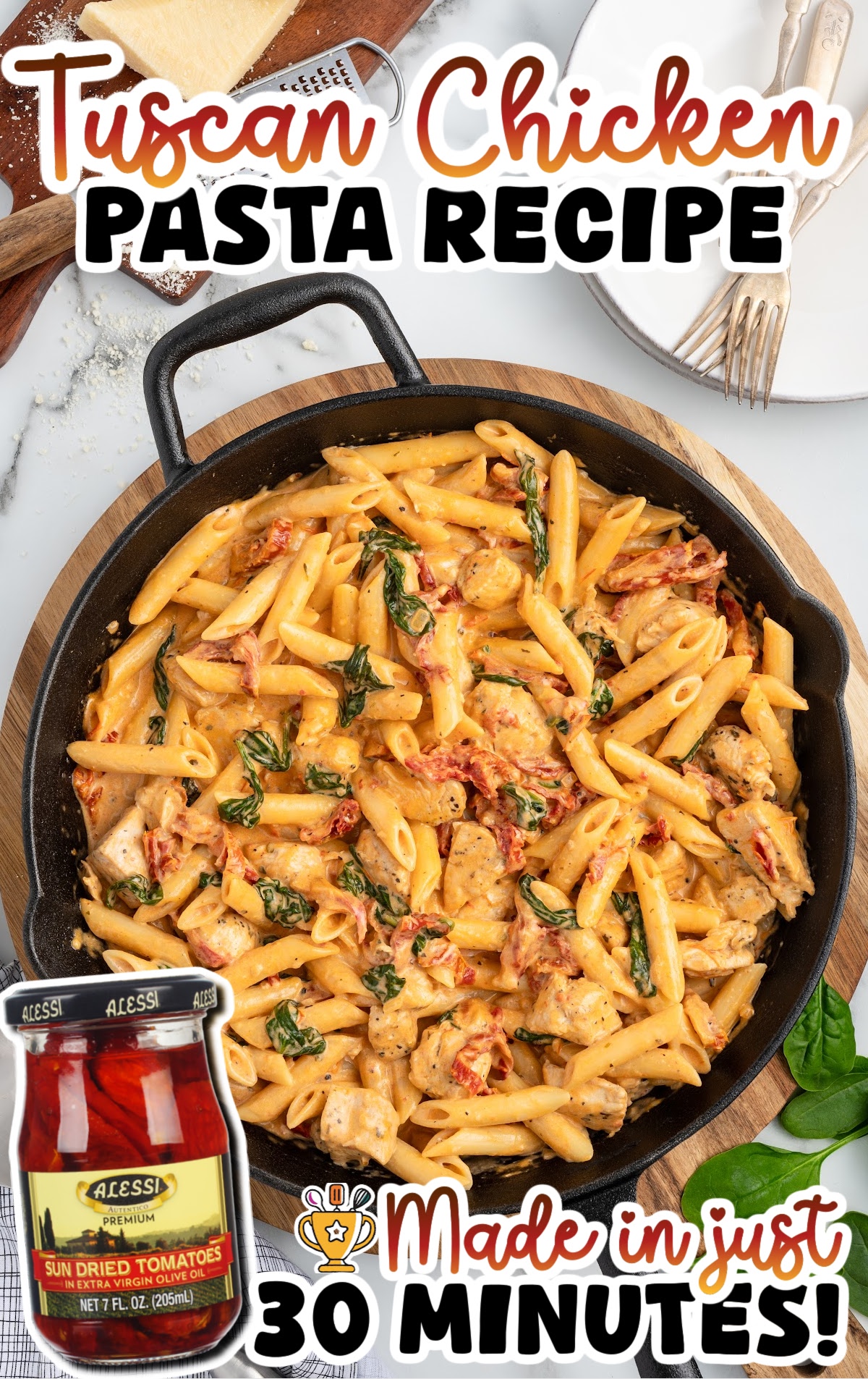 Overhead view of creamy tuscan chicken pasta in a cast iron skillet with penne, tender chicken pieces, wilted spinach, and sun-dried tomatoes in a rich cream sauce; text reads “Tuscan Chicken PASTA RECIPE” and “Made in just 30 minutes!” with a jar of sun-dried tomatoes shown in the corner.