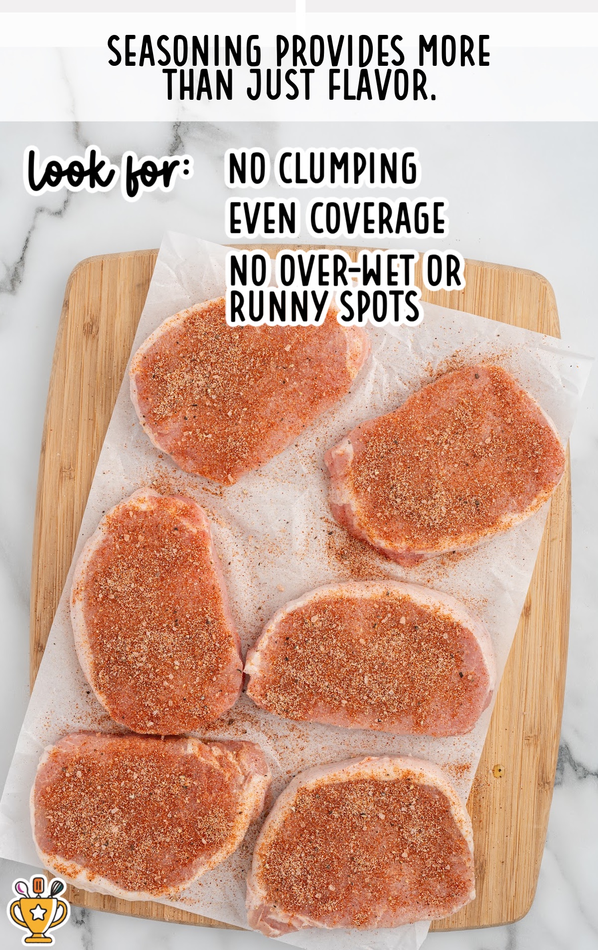 Boneless pork chops evenly seasoned with a spice rub and no breading, shown on parchment paper before cooking in the air fryer.