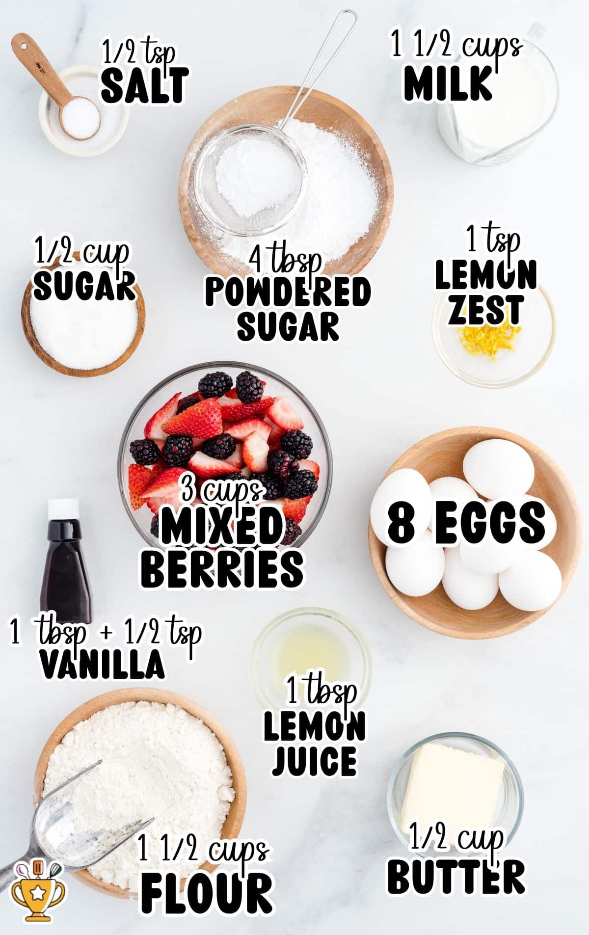 Overhead flat lay of dutch baby ingredients on a white background (eggs, milk, flour, butter, sugar, powdered sugar, vanilla, lemon zest, lemon juice, and mixed berries) with labels reading &ldquo;½ tsp SALT,&rdquo; &ldquo;1 ½ cups MILK,&rdquo; &ldquo;½ cup SUGAR,&rdquo; &ldquo;4 tbsp POWDERED SUGAR,&rdquo; &ldquo;1 tsp LEMON ZEST,&rdquo; &ldquo;3 cups MIXED BERRIES,&rdquo; &ldquo;8 EGGS,&rdquo; &ldquo;1 tbsp + ½ tsp VANILLA,&rdquo; &ldquo;1 tbsp LEMON JUICE,&rdquo; &ldquo;1 ½ cups FLOUR,&rdquo; and &ldquo;½ cup BUTTER.&rdquo;