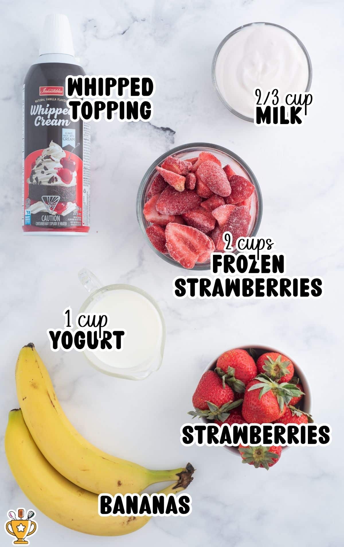 Overhead ingredients image for strawberry banana smoothie on a light marble background showing bananas, a bowl of fresh strawberries, a bowl of frozen strawberries, a measuring cup of yogurt, a small bowl of milk, and a can of whipped topping; labeled text reads “WHIPPED TOPPING,” “⅔ cup MILK,” “2 cups FROZEN STRAWBERRIES,” “1 cup YOGURT,” “STRAWBERRIES,” and “BANANAS.”