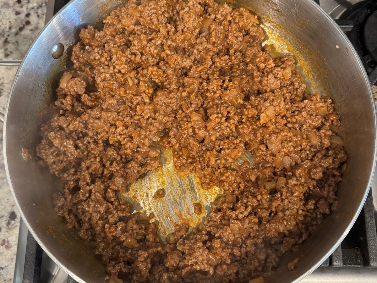 Cooked taco meat in a skillet, thick and well-coated in sauce with no excess liquid pooling, showing the proper consistency for filling taco shells.