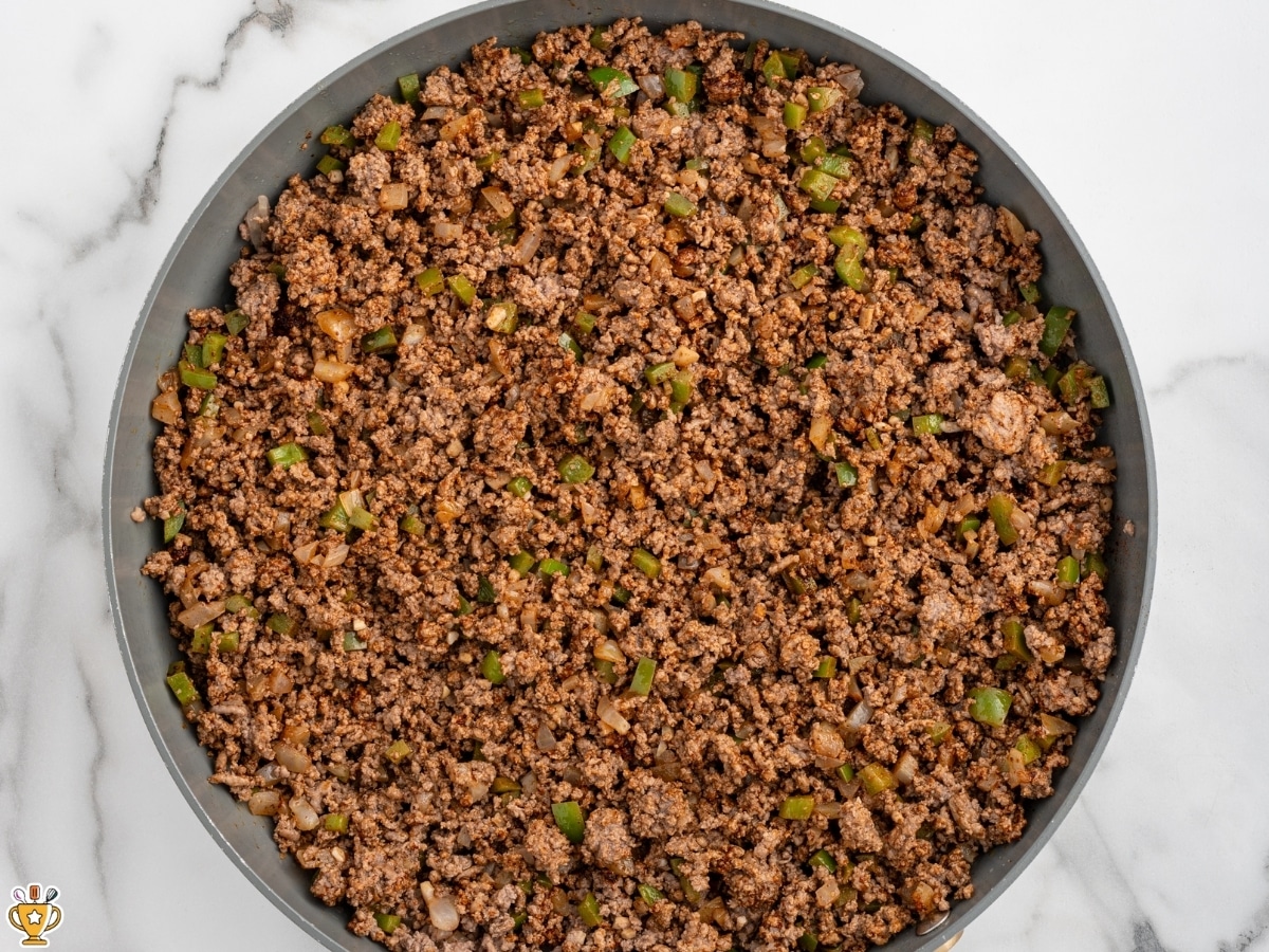 Ground beef browned with onion, green bell pepper, garlic, and chili powder in a skillet as the base for crockpot chili.