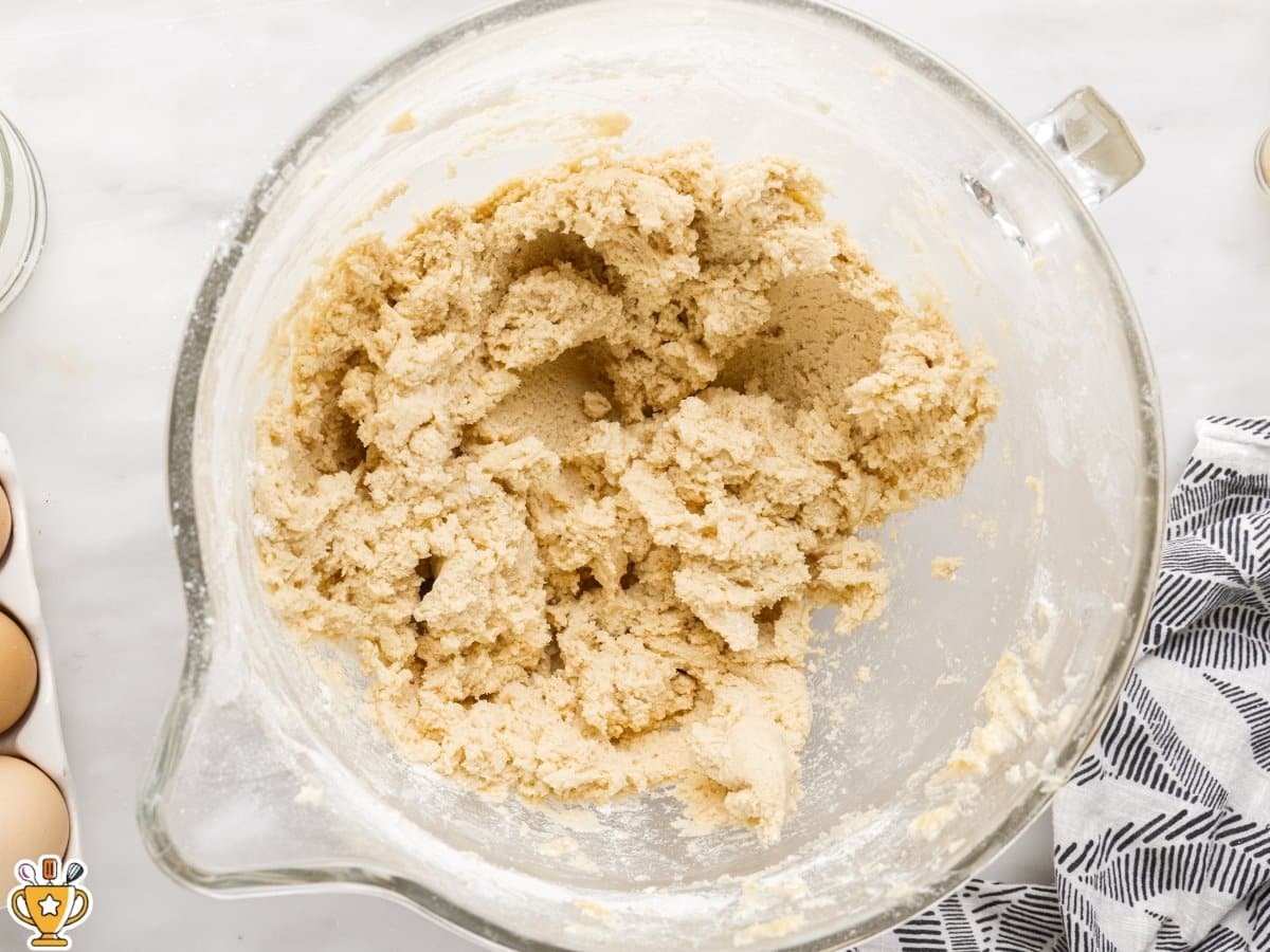 soft sugar cookie dough fully mixed in a glass mixing bowl, thick and slightly fluffy texture on a white marble countertop